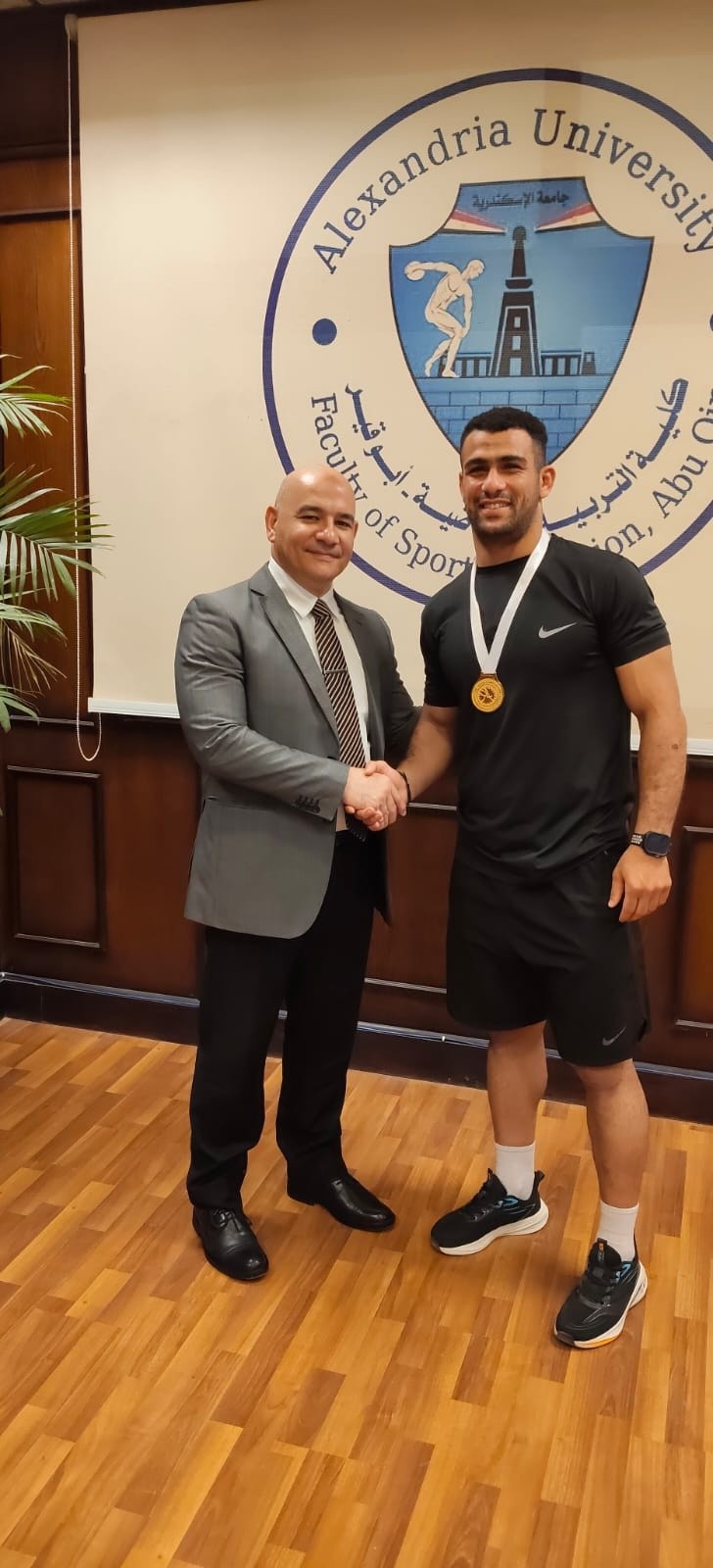 The Dean of the College congratulates student Emad Ashraf Mohamed for achieving third place in wrestling.